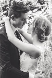 A black and white photo of a young bride and groom staring into each other's eyes while embracing.
